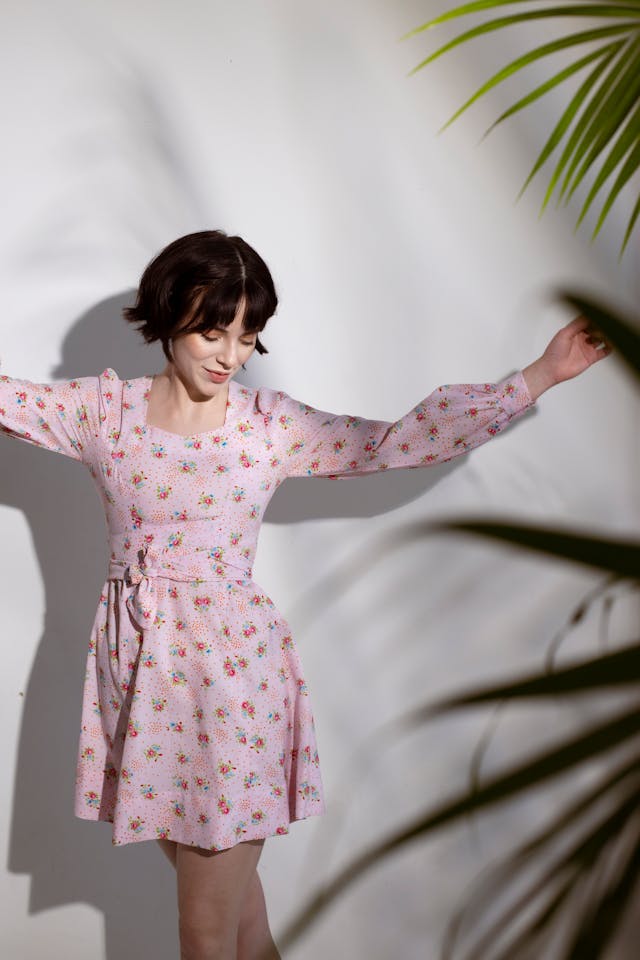 woman in pink dress dances indoors