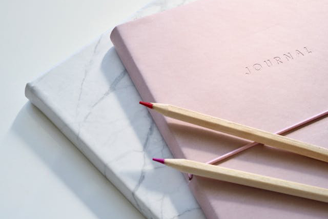 pink journal with pencils