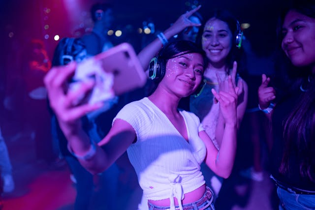 young woman takes self in dance club atmosphere